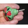 green pear shaped button and red flower