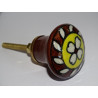 brown and yellow porcelain button with white flower